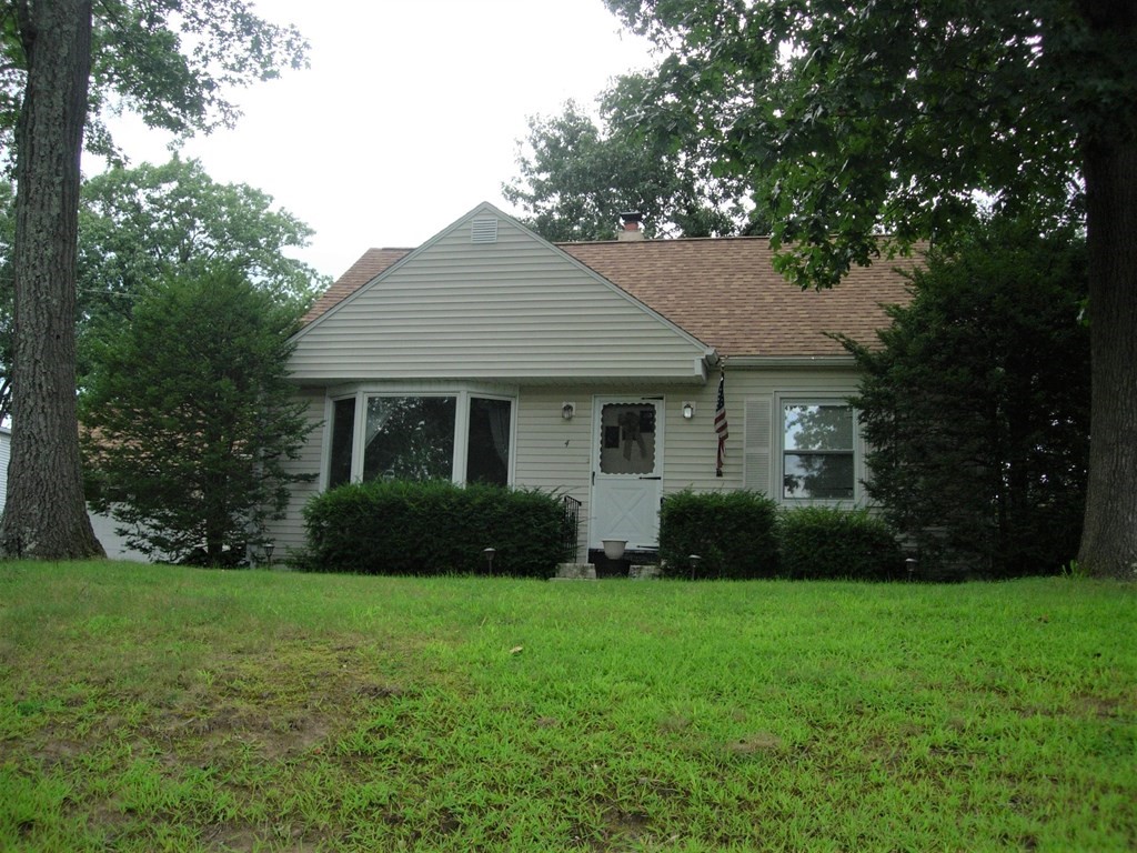 a front view of a house with garden and yard