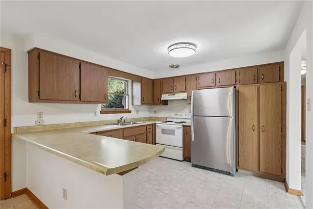 a kitchen with a refrigerator sink and cabinets
