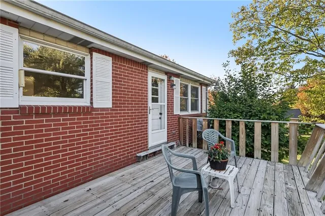 a balcony with wooden floor table and chairs