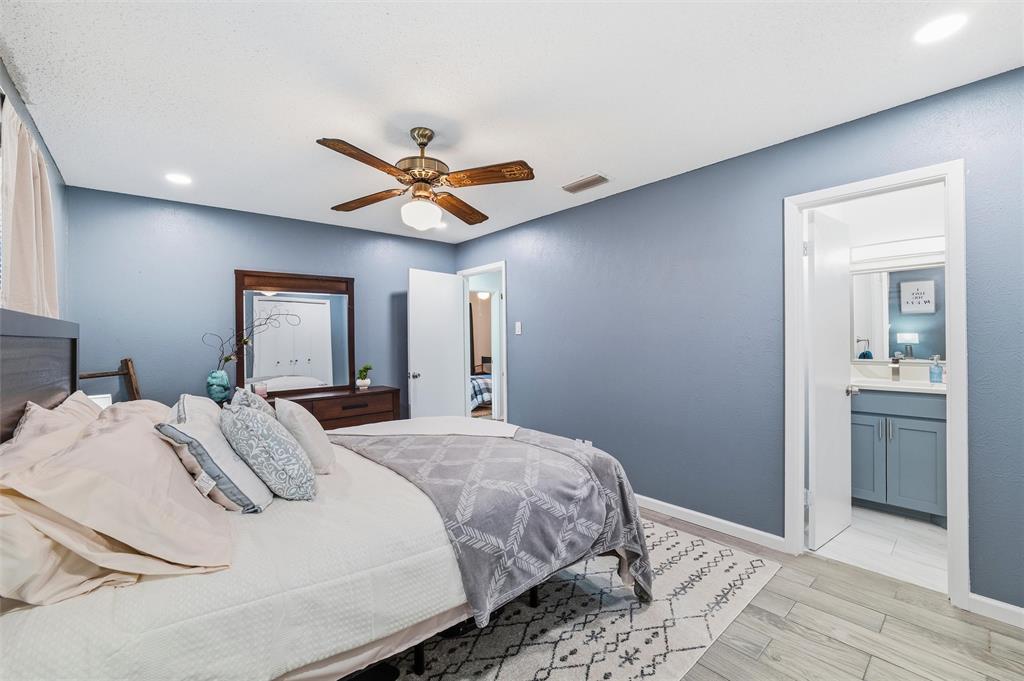 1801 Homestead Place Garland, TX 75044 - Photo 20 of 37 a bedroom with a bed and a chandelier