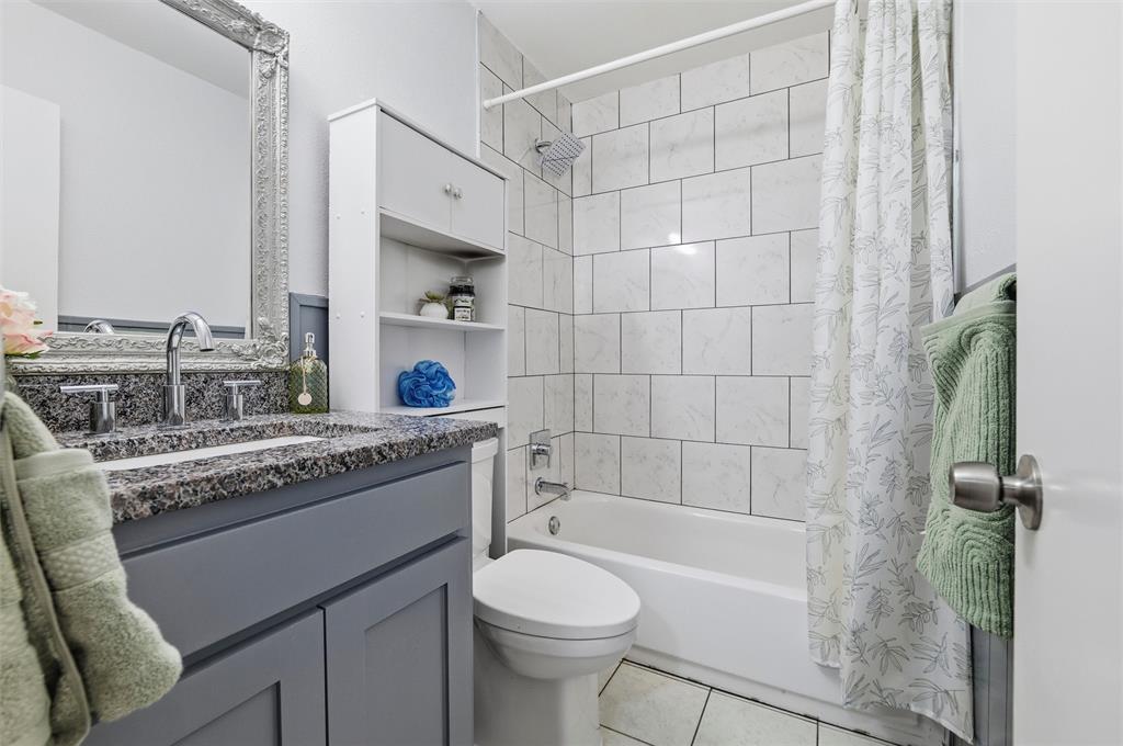 1801 Homestead Place Garland, TX 75044 - Photo 22 of 37 a bathroom with a granite countertop toilet sink and mirror