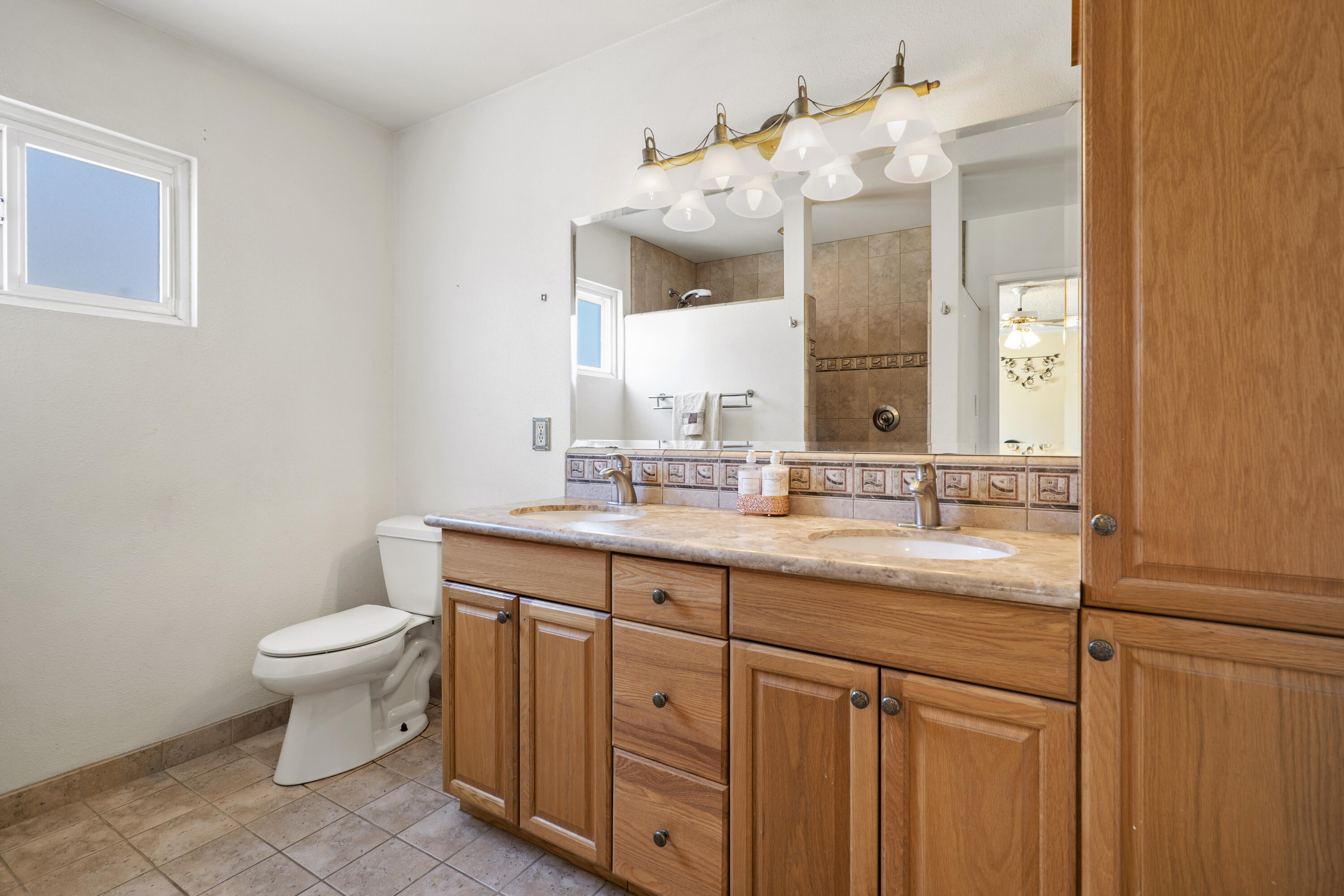 41235 47th Street West Lancaster, CA 93536 - Photo 16 of 43 a bathroom with a double vanity sink and a toilet