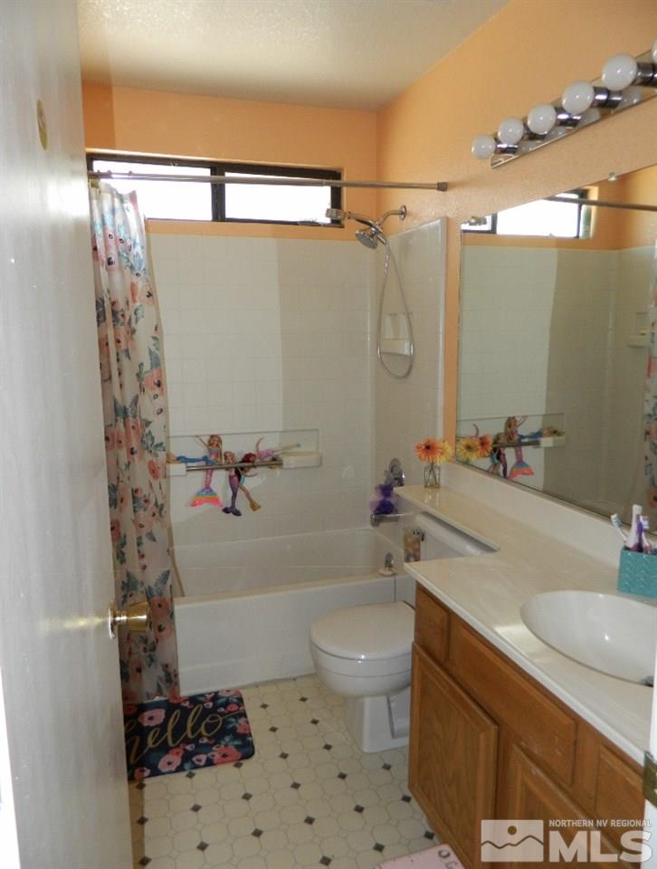 5885 Starcrest Avenue Reno, NV 89523 - Photo 16 of 18 a bathroom with a sink toilet and shower