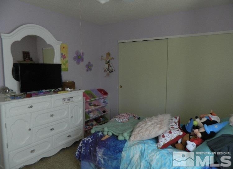 5885 Starcrest Avenue Reno, NV 89523 - Photo 17 of 18 a bedroom with a bed and flat screen tv