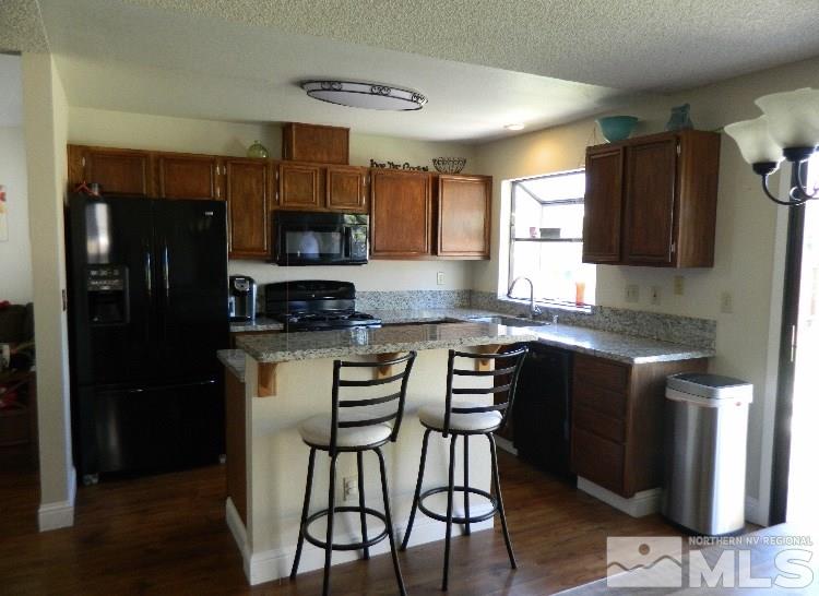 5885 Starcrest Avenue Reno, NV 89523 - Photo 5 of 18 a kitchen with granite countertop a refrigerator stove top oven and sink