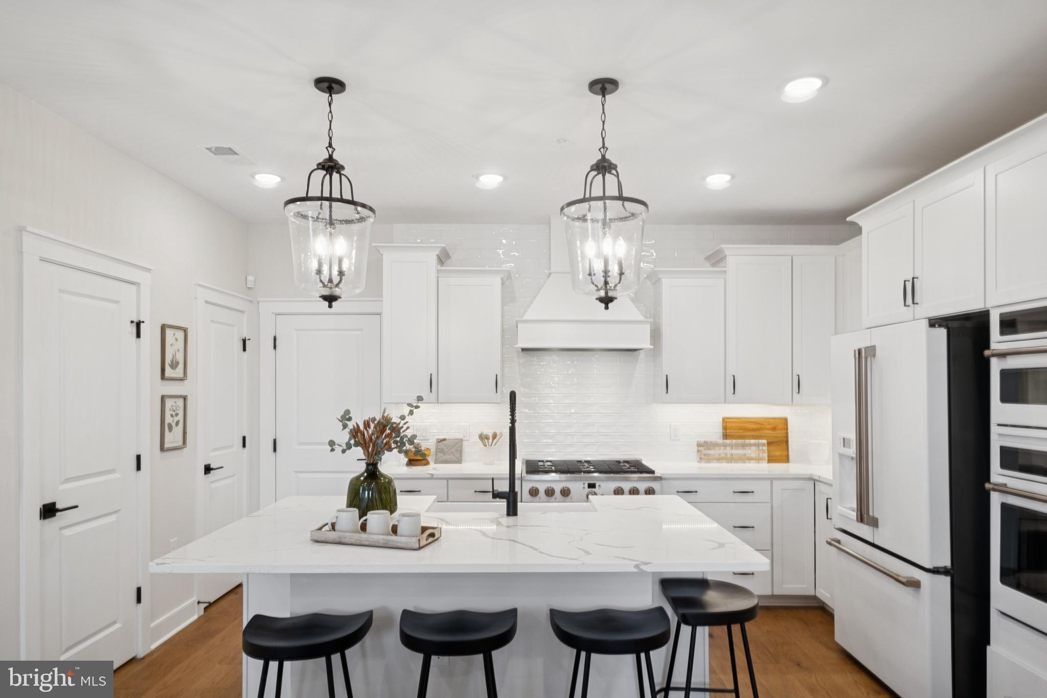 14937 Deco Circle Chantilly, VA 20151 - Photo 14 of 35 a kitchen with stainless steel appliances a dining table chairs and white cabinets