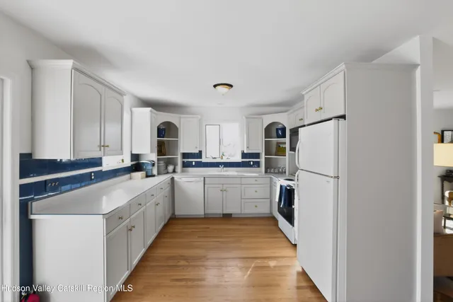 a kitchen with white cabinets and white appliances
