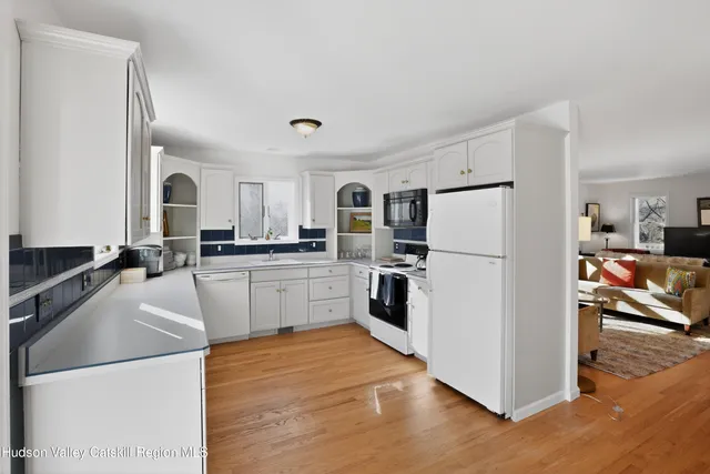 a kitchen with granite countertop a refrigerator stove top oven and sink
