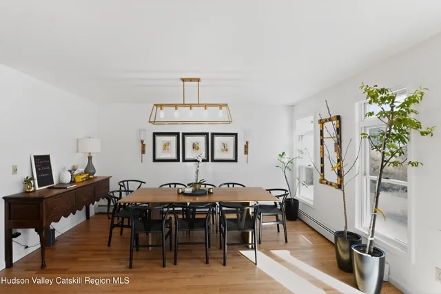 a view of a a dining room with furniture window and wooden floor