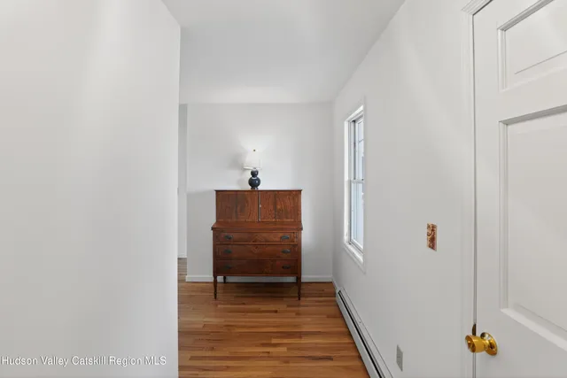 a view of a hallway with wooden floor and closet