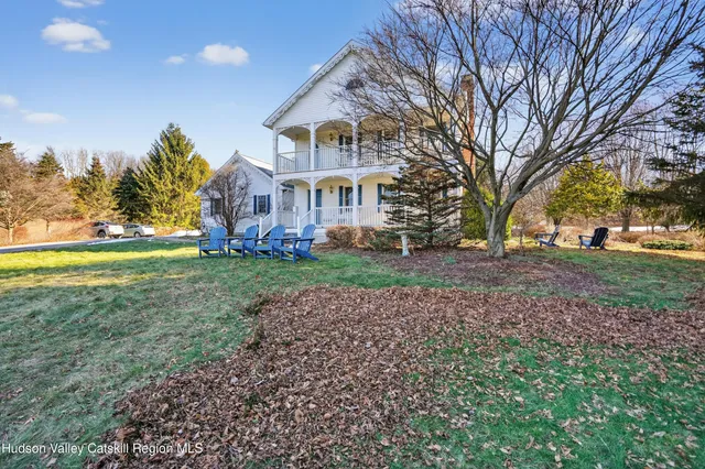 a view of a big house with a big yard and large trees