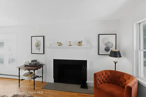 a living room with furniture a fireplace and a mirror