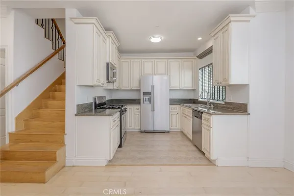 a kitchen with white cabinets and white appliances