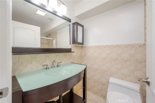 a bathroom with a sink a toilet and mirror