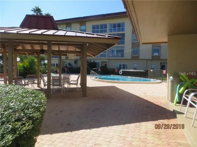 a view of a patio with a table and chairs and potted plants