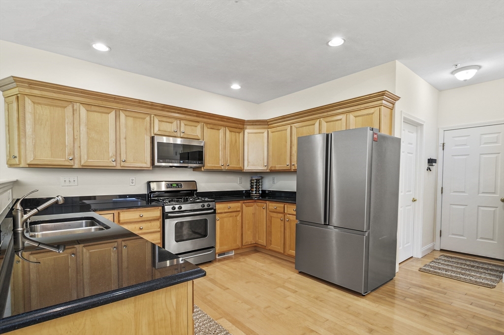 508 Linwood Court, Unit 508 Clinton, MA 01510 - Photo 11 of 32 a kitchen with stainless steel appliances granite countertop a refrigerator stove and sink