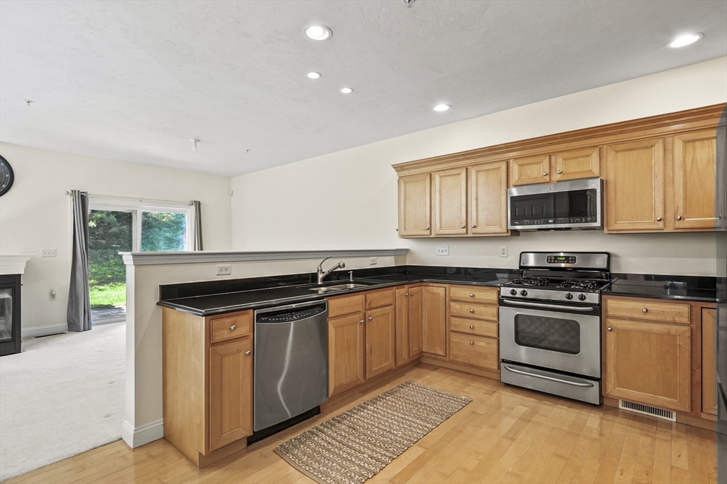 508 Linwood Court, Unit 508 Clinton, MA 01510 - Photo 13 of 32 a kitchen with stainless steel appliances granite countertop a stove a sink and a microwave