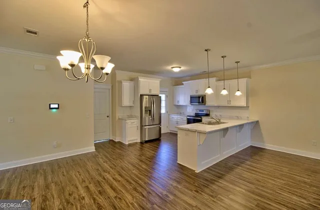 a kitchen with stainless steel appliances granite countertop a sink stove and a wooden floor