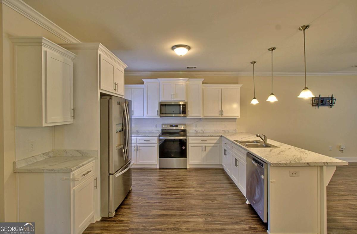 455 Bluff Road Jesup, GA 31545 - Photo 5 of 22 a kitchen with stainless steel appliances granite countertop a sink a stove and a refrigerator