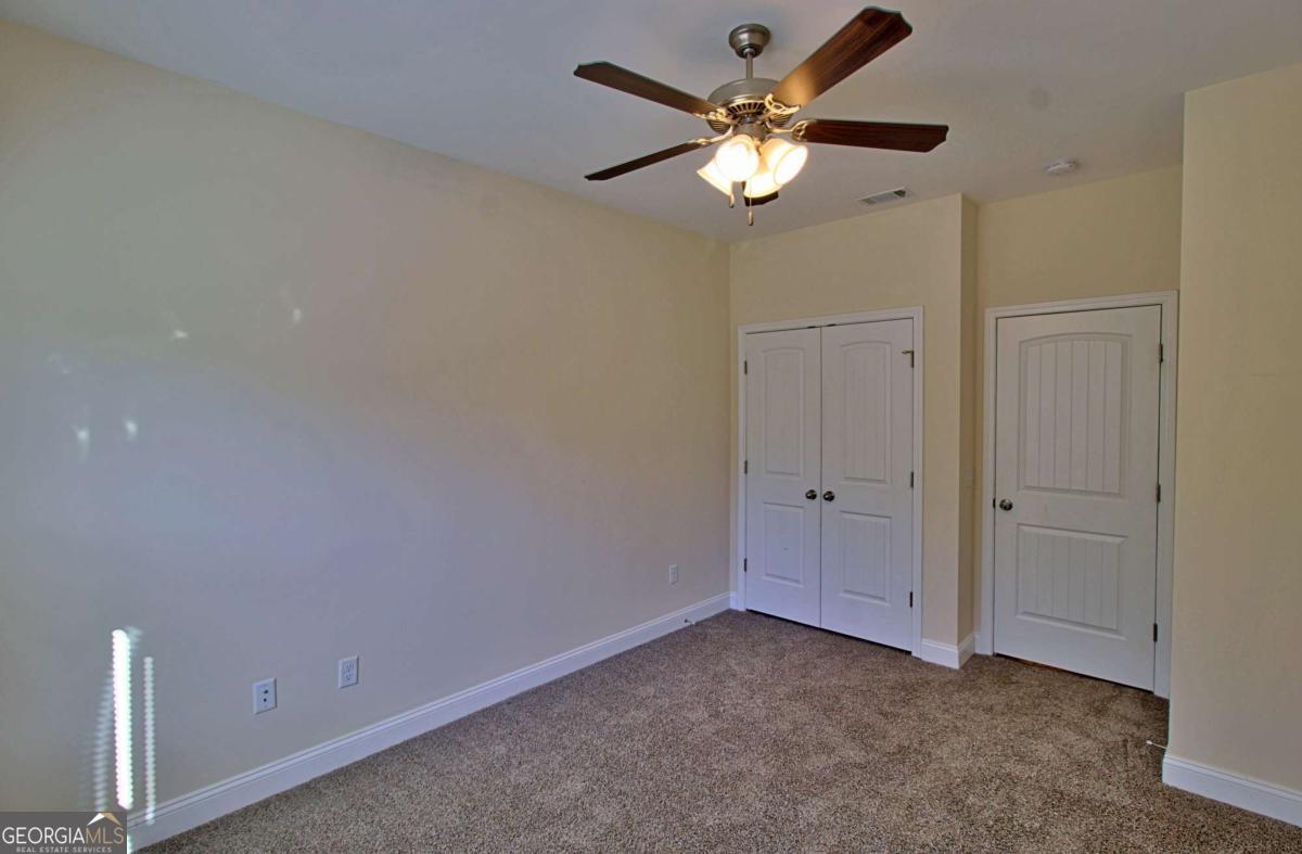 455 Bluff Road Jesup, GA 31545 - Photo 9 of 22 an empty room with a chandelier fan and a chandelier fan