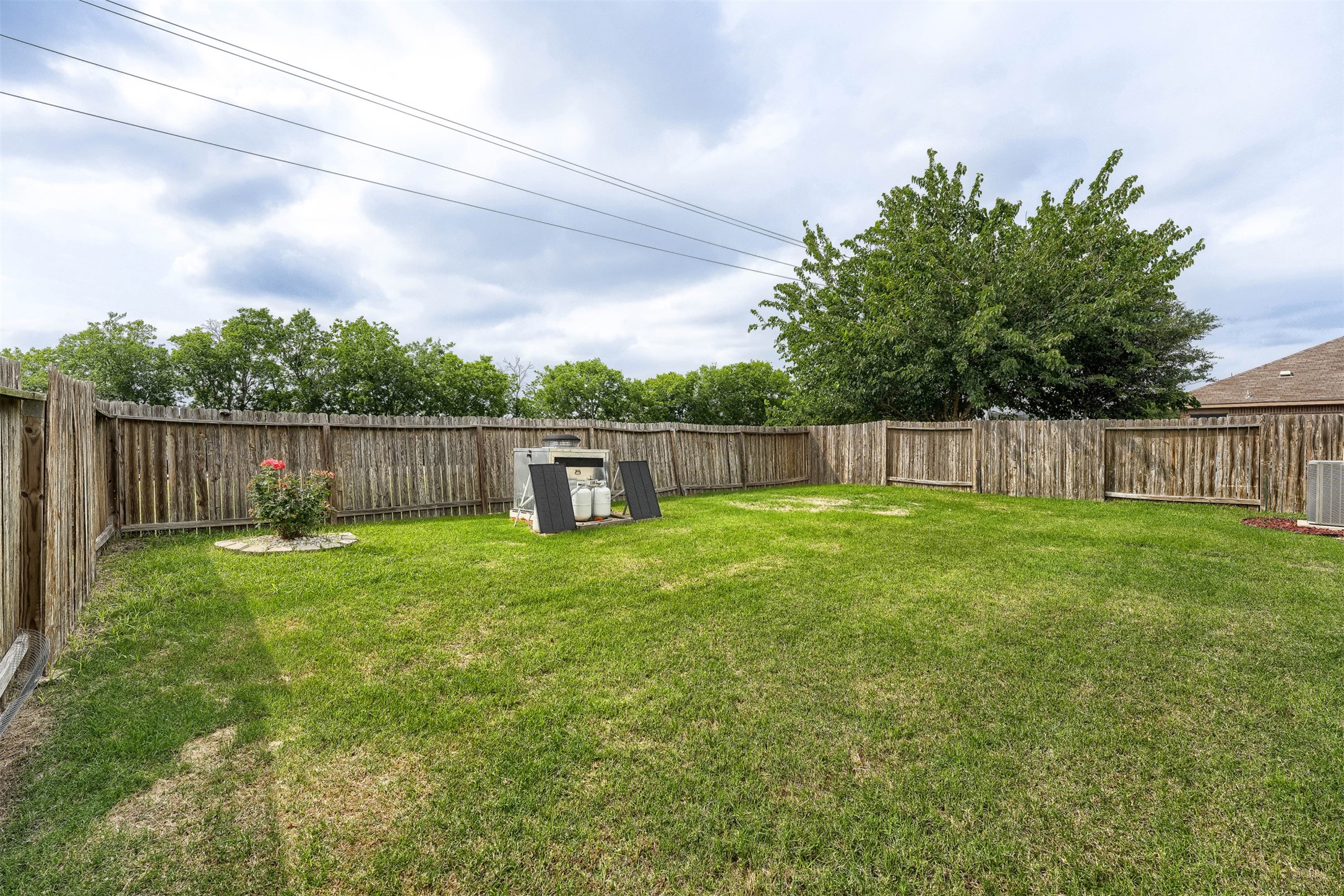 13408 Clara Martin Road Manor, TX 78653 - Photo 26 of 27 a view of a backyard with large trees and wooden fence