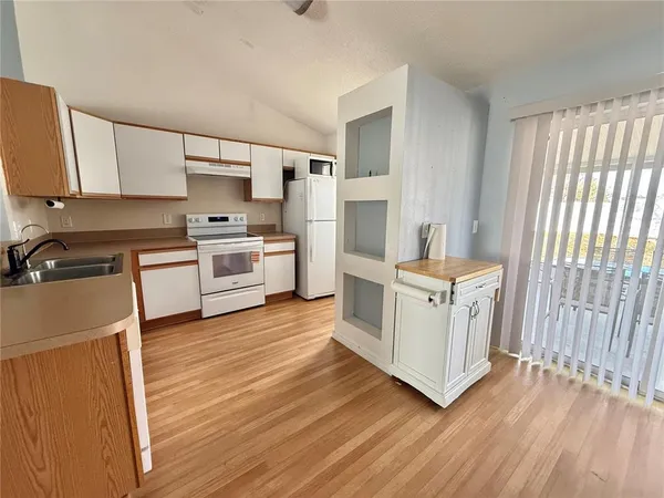 a kitchen with stove cabinets and wooden floor
