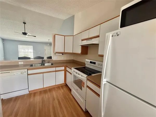 a kitchen with white cabinets and white appliances