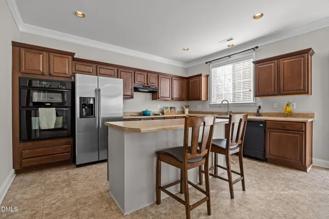 a kitchen with stainless steel appliances a refrigerator stove microwave and sink