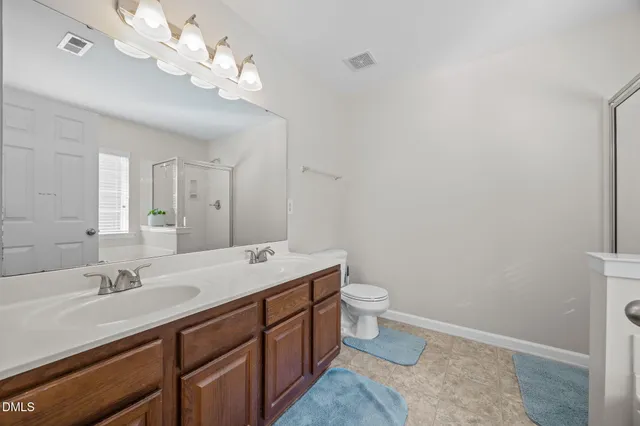 a spacious bathroom with a toilet a sink and a mirror