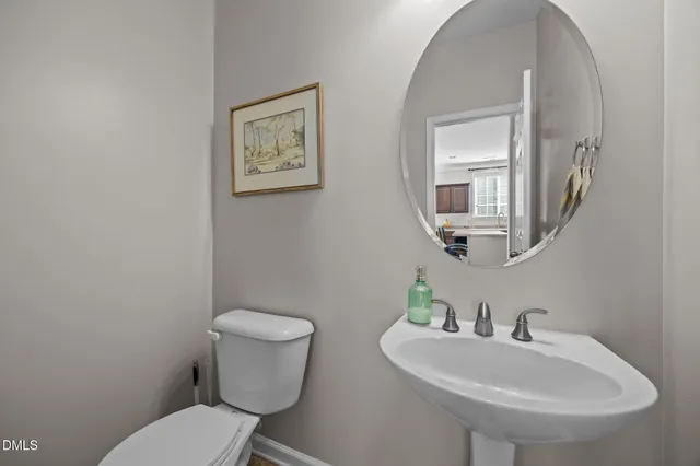 a bathroom with a toilet a sink and mirror