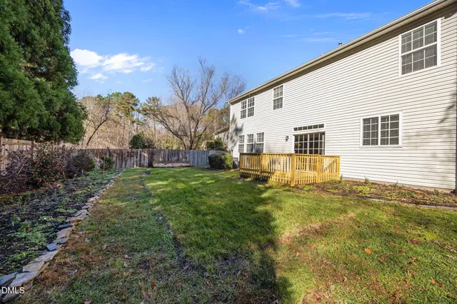 a view of a yard with plants and trees