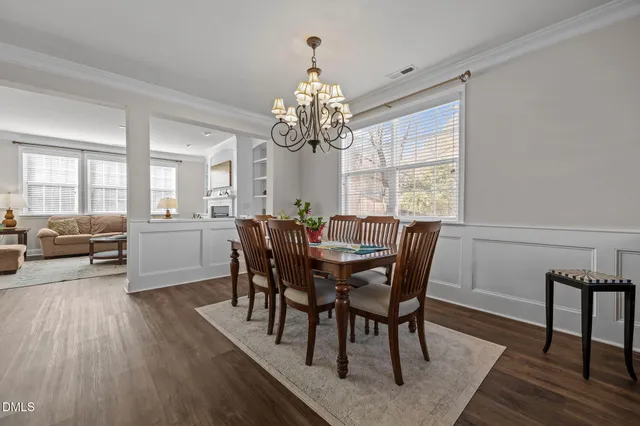 a view of a dining room with furniture a chandelier and wooden floor