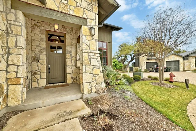 a view of a house with a patio and a yard
