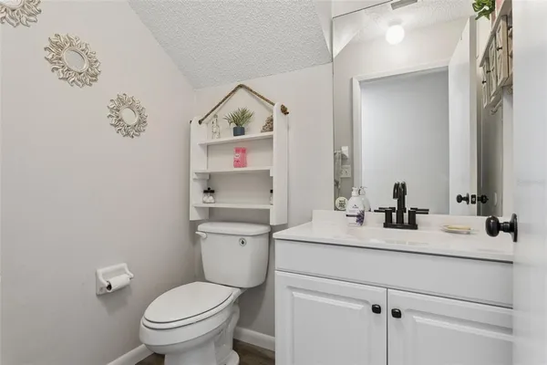 a bathroom with a sink vanity mirror and toilet