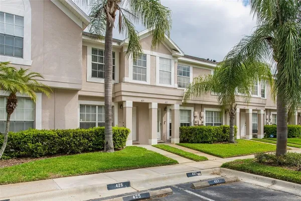 a front view of a house with a yard and potted plants
