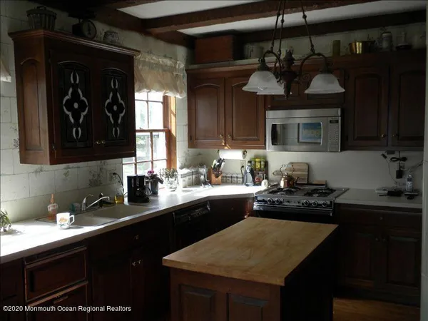 a kitchen with stainless steel appliances granite countertop a sink a stove and cabinets