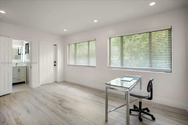 a view of a workspace with furniture and a window