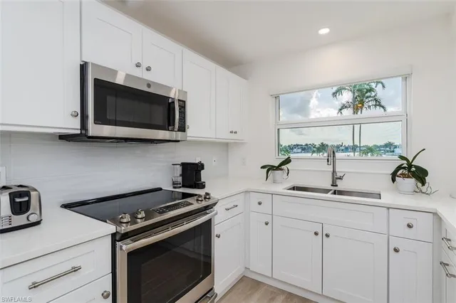 a kitchen with white cabinets and appliances