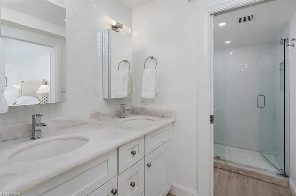 a bathroom with double sink and a mirror