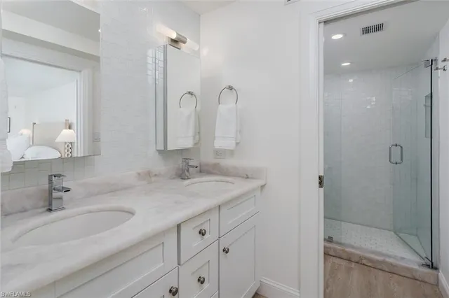a bathroom with double sink and a mirror