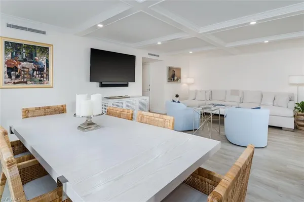 a living room with furniture a flat screen tv and kitchen view