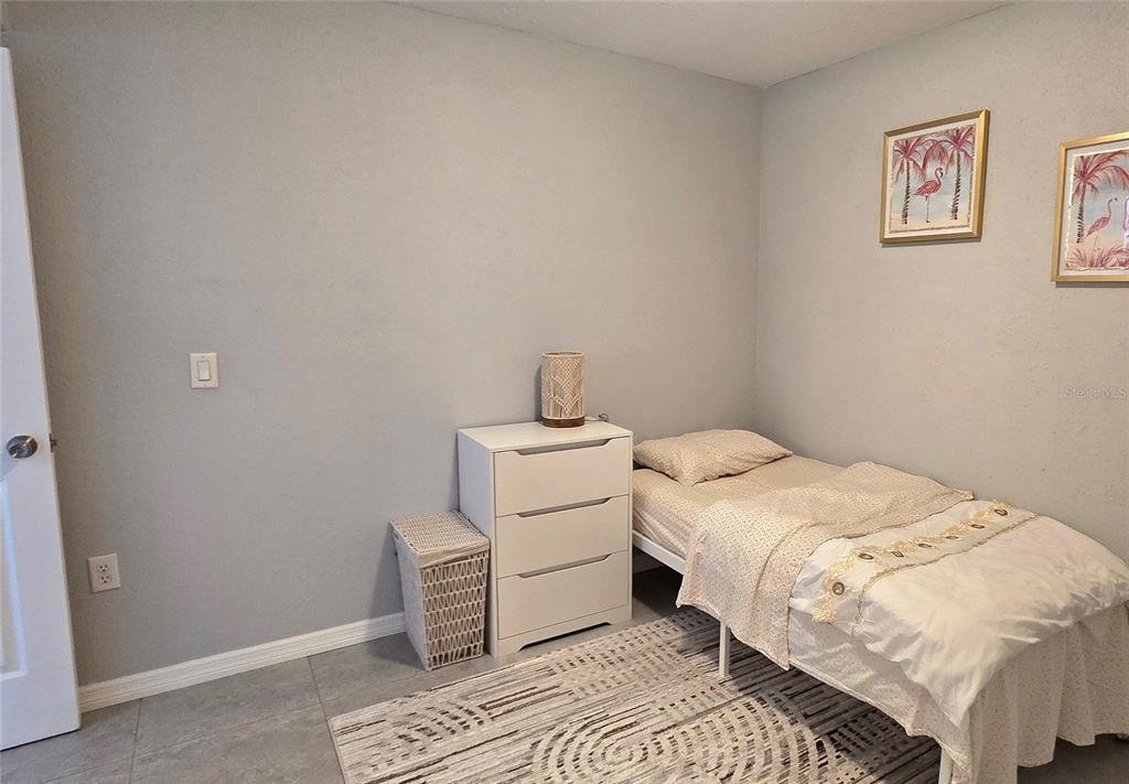 245 Center Road, Unit 104 Venice, FL 34285 - Photo 28 of 37 a bedroom with a bed and a lamp
