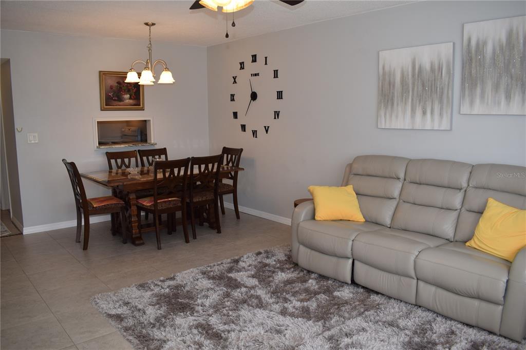245 Center Road, Unit 104 Venice, FL 34285 - Photo 9 of 37 a living room with furniture and a chandelier