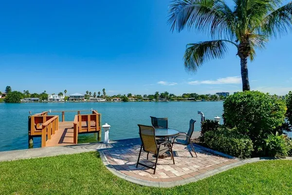 a view of chairs and table in patio with a lake view