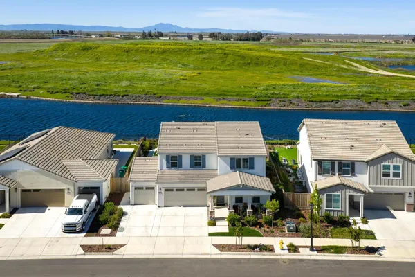 an aerial view of residential houses with outdoor space and ocean view