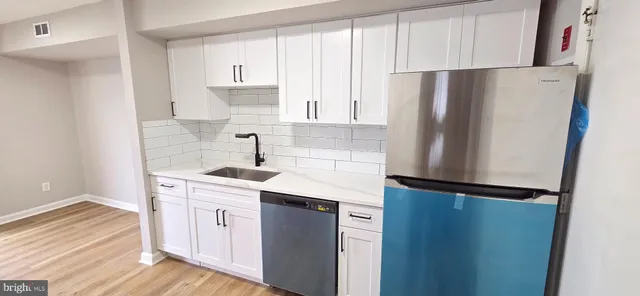 a kitchen with granite countertop a stove and a wooden floor