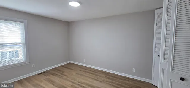 a view of a room with wooden floor and closet area
