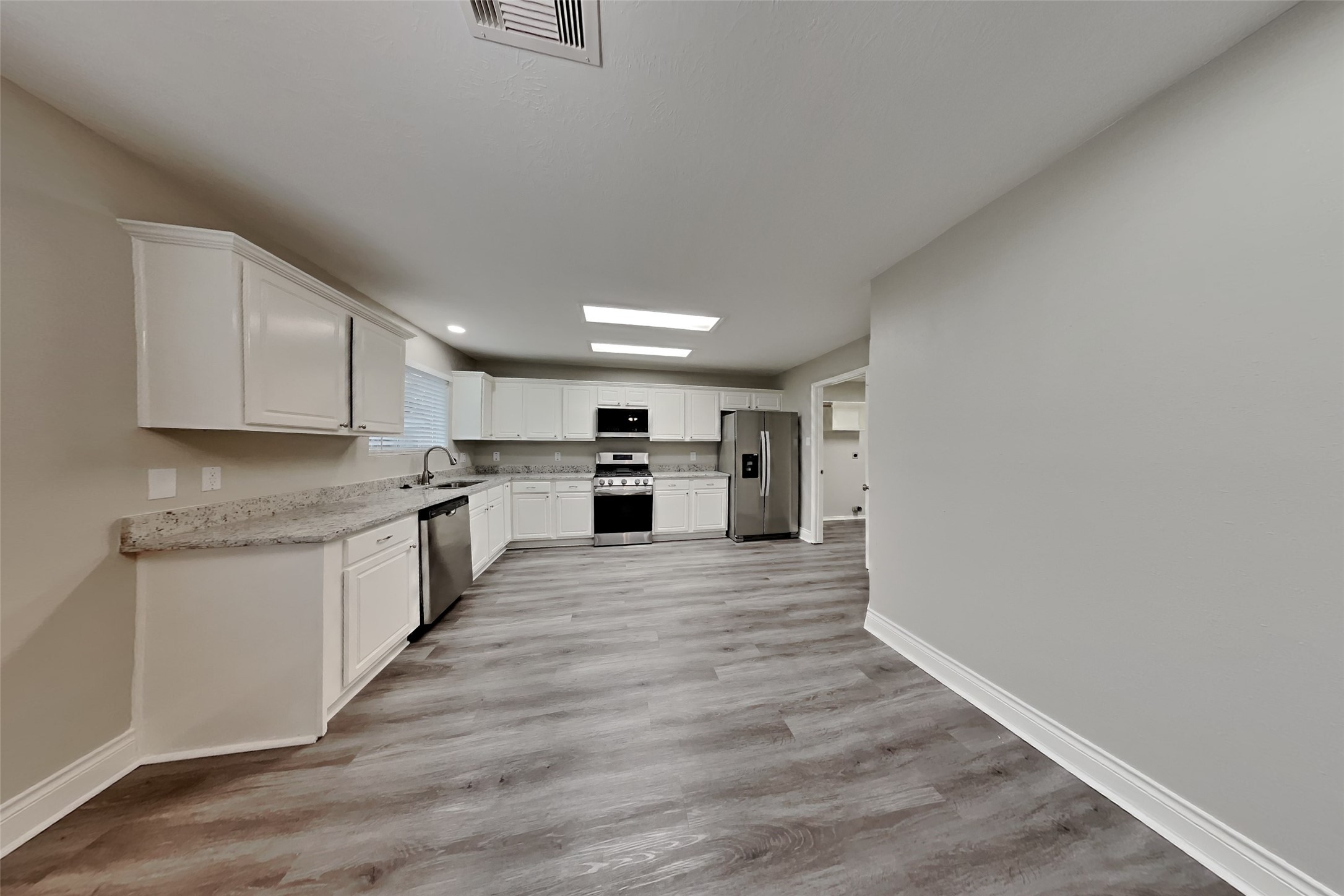 20314 Savannah Bay Road Cypress, TX 77433 - Photo 3 of 21 a large kitchen with white cabinets stainless steel appliances