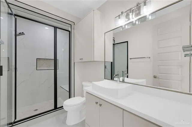 a bathroom with a sink a toilet and shower