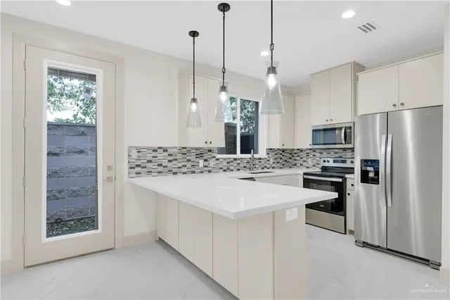 a kitchen with stainless steel appliances a stove a sink island and a refrigerator